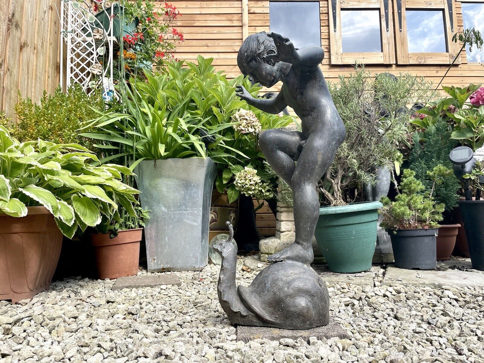 Bronzed Garden Water Feature of a Boy Stood on a Snail